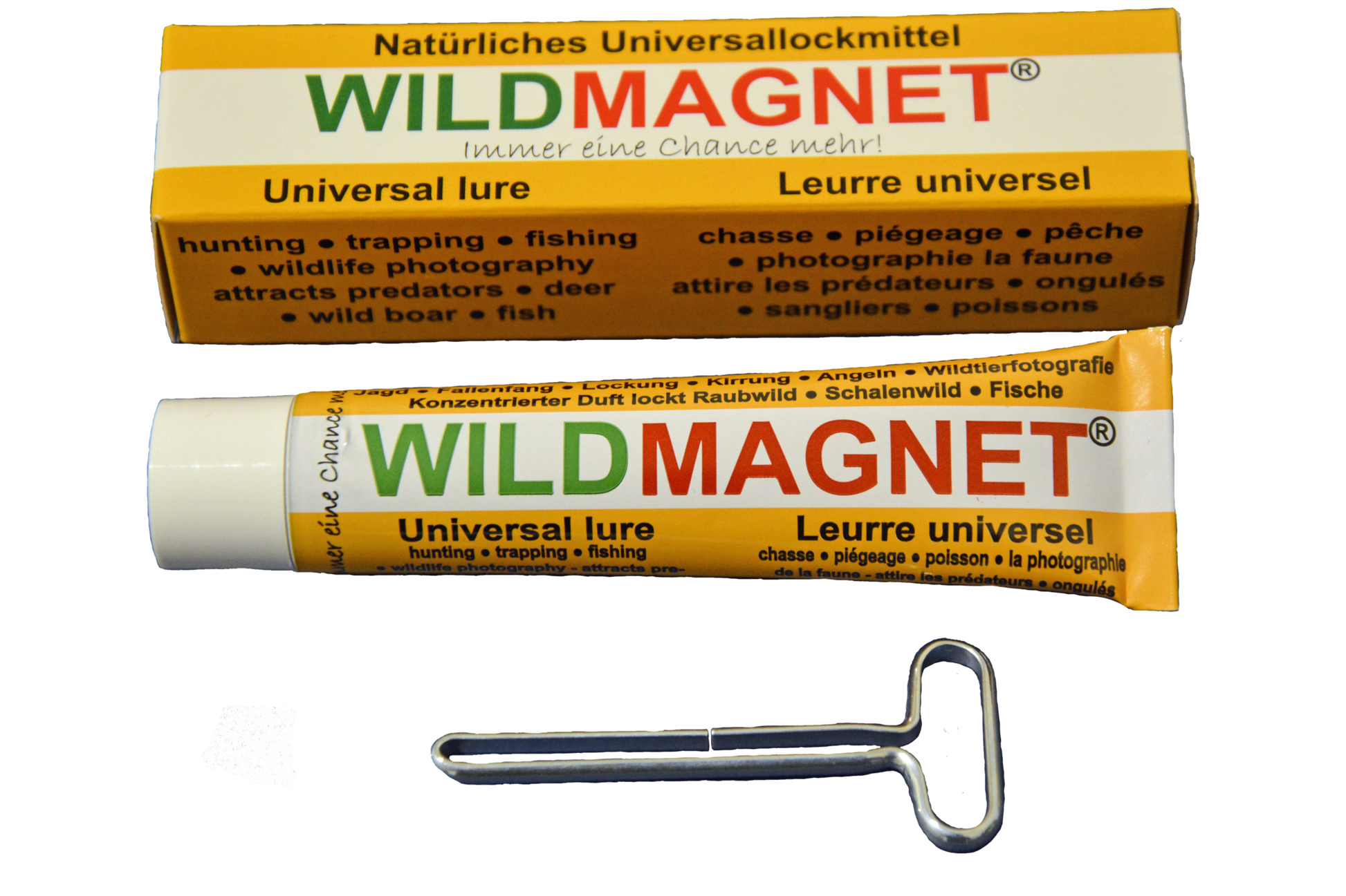 Eine Tube „WILDMAGNET®“ – ein natürliches Universallockmittel – zusammen mit der zugehörigen Verpackung und einem Metallschlüssel zum Ausdrücken der Tube. Die Beschriftung ist mehrsprachig (Deutsch, Englisch, Französisch) und beschreibt die Anwendung für Jagd.