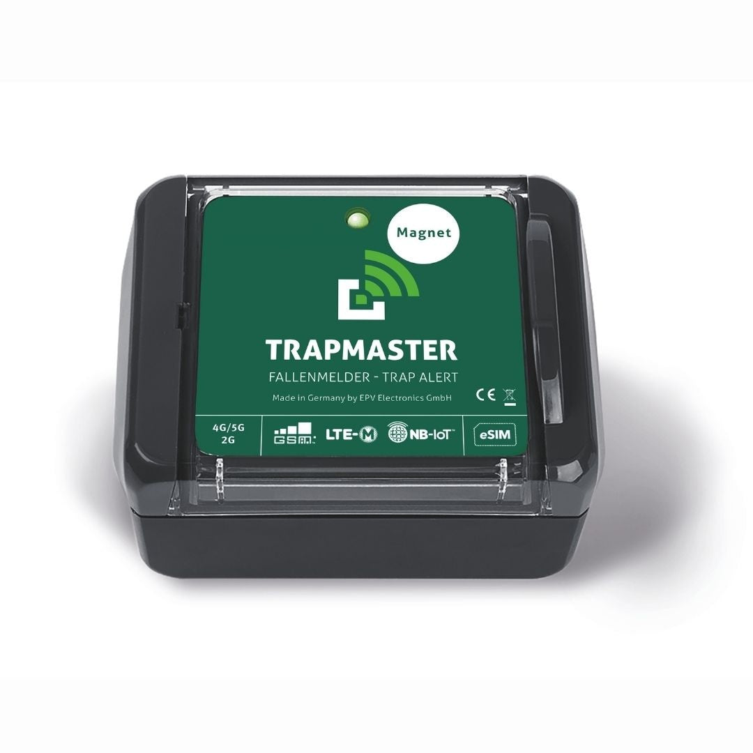 Elektronischer Fallenmelder TRAPMASTER mit grünem Etikett, auf dem „Magnet“ steht. Das Gerät verfügt über ein kompaktes schwarzes Gehäuse und unterstützt Mobilfunkstandards wie GSM, LTE-M, NB-IoT sowie eSIM. Die Status-LED ist gut sichtbar im oberen Bereich integriert.